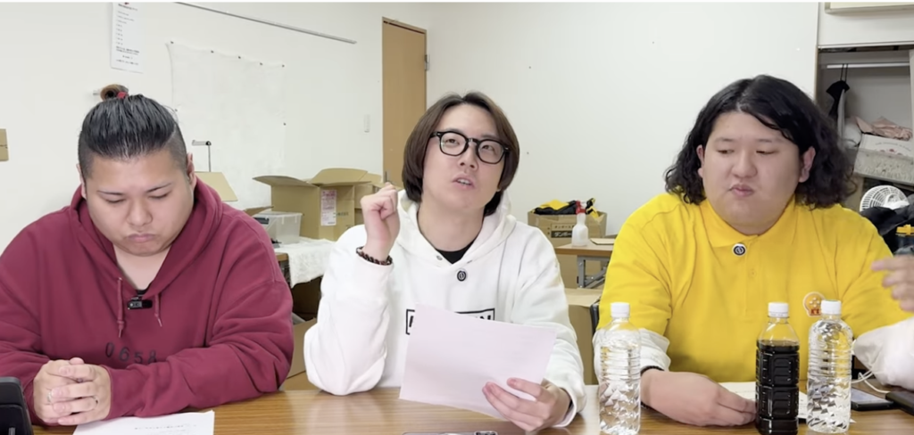 堀田さんを含め3人が正面に座っている様子。