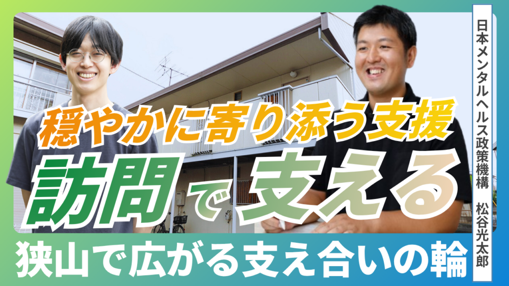 日本メンタルヘルス政策機構の施設を背景に代表の松谷さんとパパゲーノ代表のやすまさが映っています。